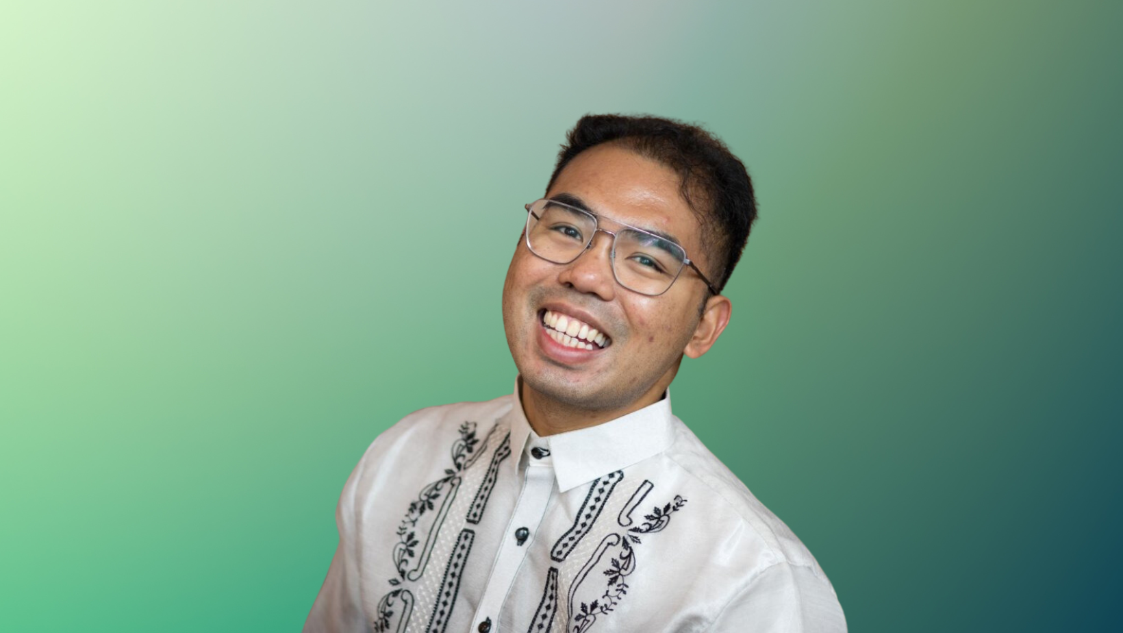 Headshot of a man smiling with green background.