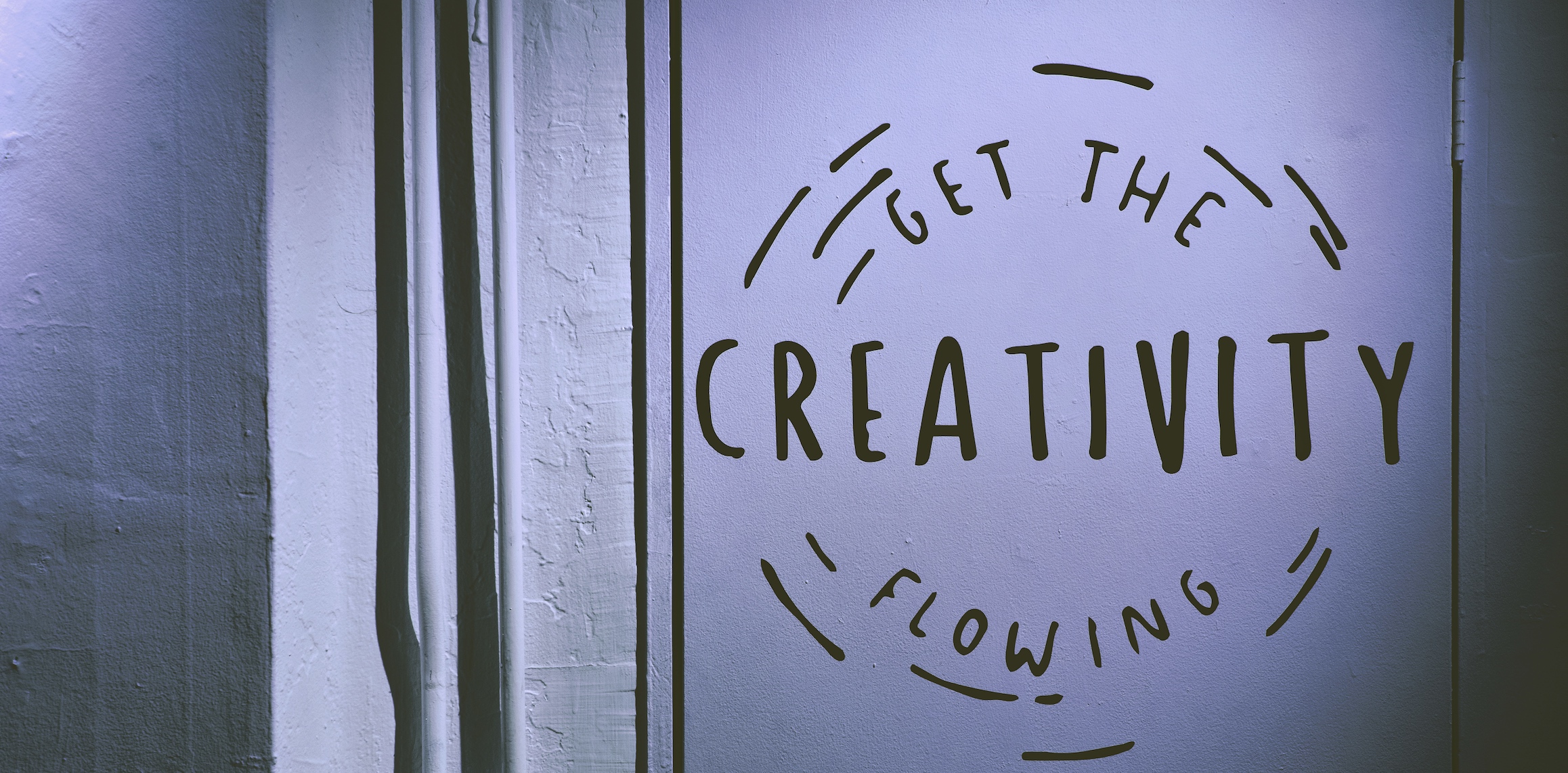 White wall with a painting of two circles and text that reads, Get the Creativity Flowing