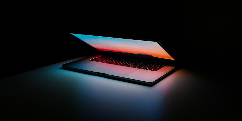 Lit up laptop in the dark.