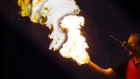Man holding fire in one hand and the other holds a lighter.