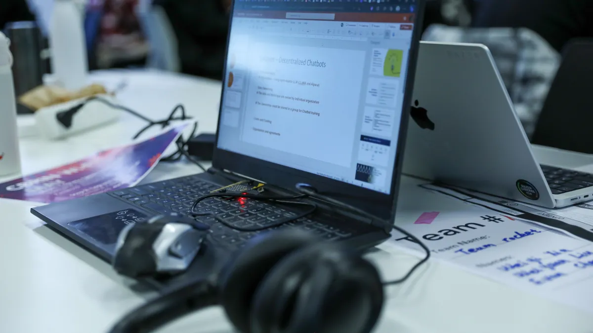 A laptop with headphones, mouse, and an extra hard drive. 