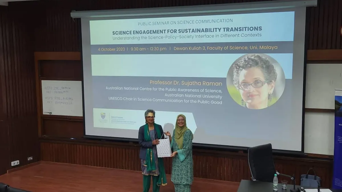 A women presenting another woman a gift for their presentation. 