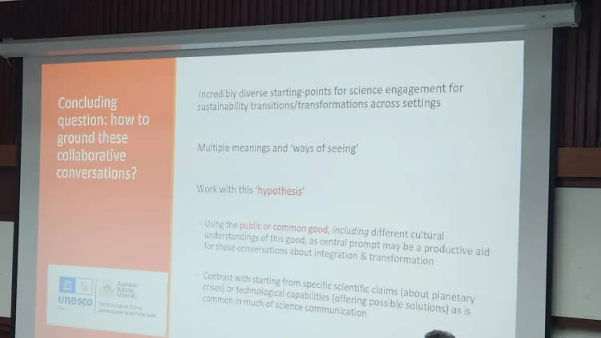 A woman presenting a powerpoint slide with text on the slide the reads, 'Concluding remarks'