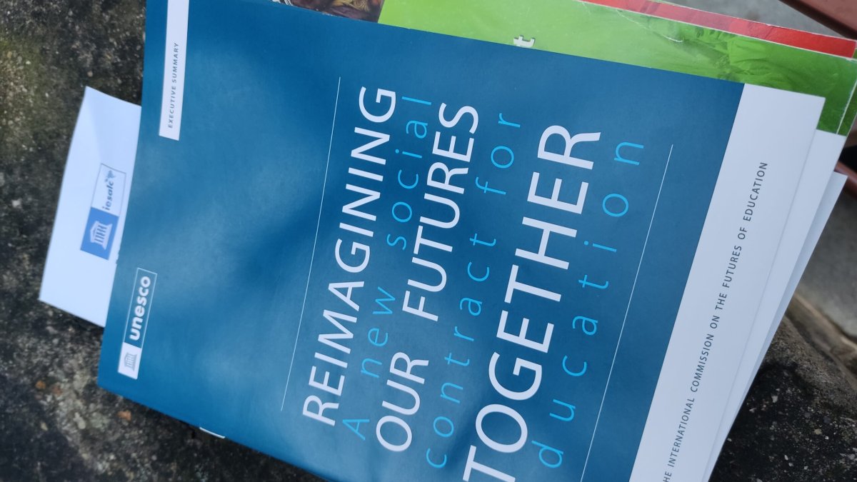 Blue printed program for the UNESCO 30th anniversary with text "Reimagining our futures together: A new social contract for education"