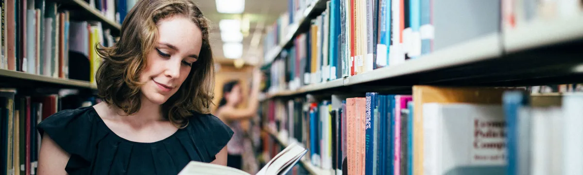 A woman reading books in a library