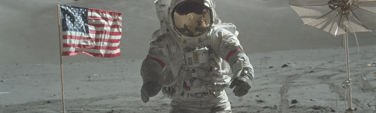 Astronaut walking on the moon with an American flag and a satellite in the background.