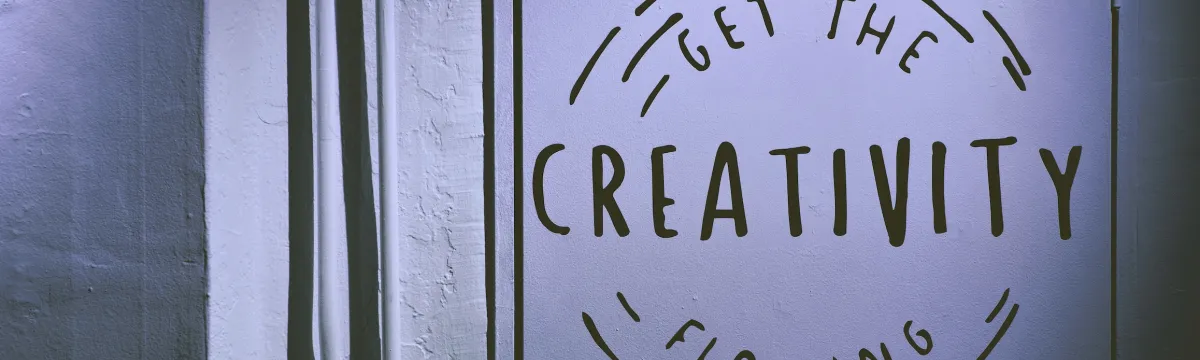 White wall with a painting of two circles and text that reads, Get the Creativity Flowing