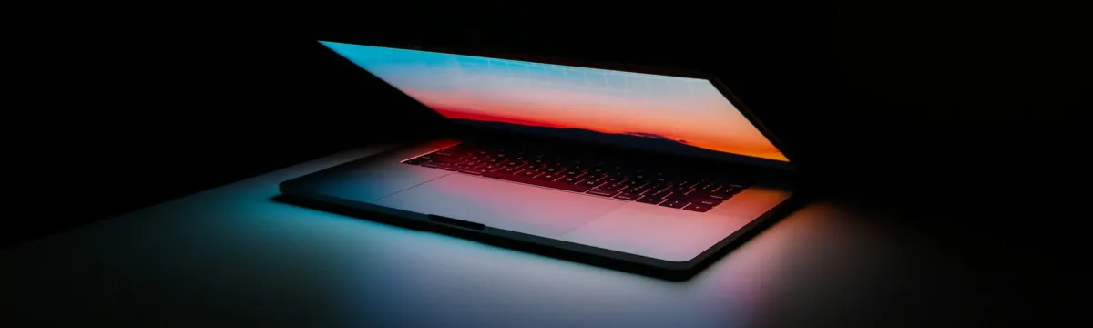 Dark room with an active laptop glow.