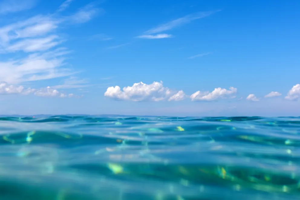 Image at the water level of the sky, showing the many blues of the ocean and sky.