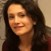 Headshot of a woman with her hair down in a red jumper.