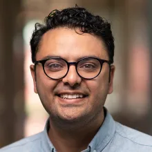 Headshot of man with round glasses.
