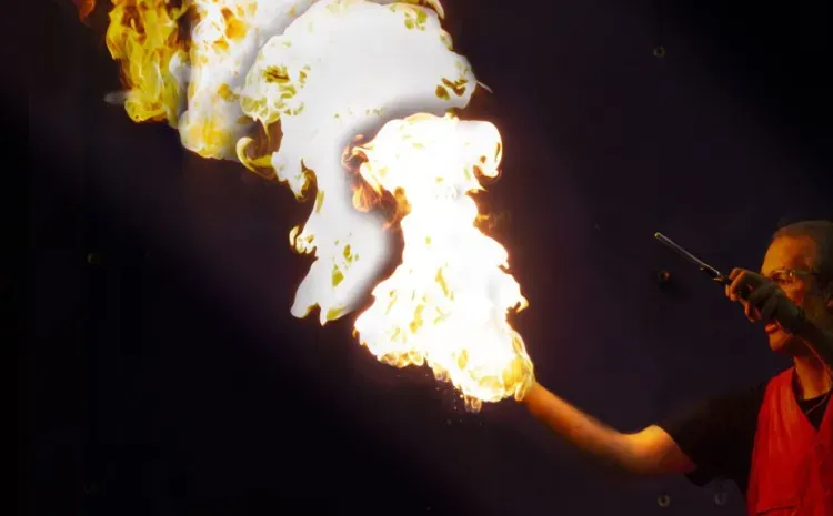 Man holding fire in one hand and the other holds a lighter.