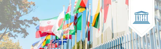 A row of flags on poles with a bookmark overlaid on top of the image with the UNESCO logo.